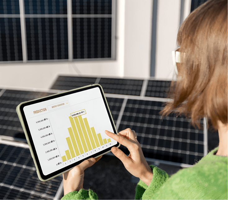Person analyzing solar production data on a tablet